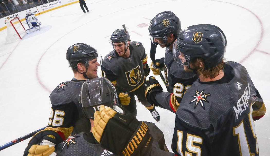 Golden Knights players, from left, Paul Stastny (26), Jonathan Marchessault, Nick Holden, and Jon Merrill celebrate a goal by Reilly Smith, lower left, during the first period of an NHL hockey gam ...