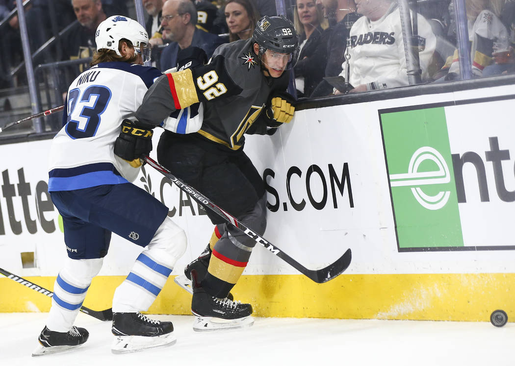 Golden Knights left wing Tomas Nosek (92) battles for the puck against Winnipeg Jets defenseman Sami Niku (83) during the second period of an NHL hockey game at T-Mobile Arena in Las Vegas on Thur ...