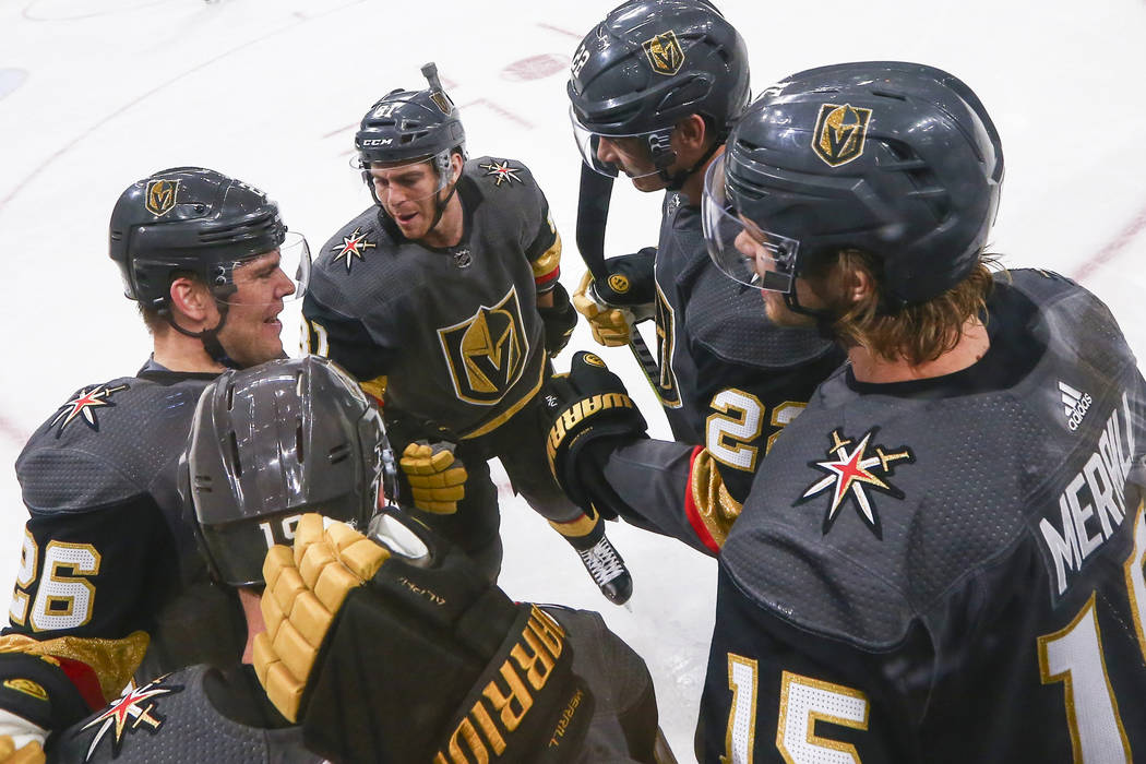 Golden Knights players, from left, Paul Stastny (26), Jonathan Marchessault, Nick Holden, and Jon Merrill celebrate a goal by Reilly Smith, lower left, during the first period of an NHL hockey gam ...