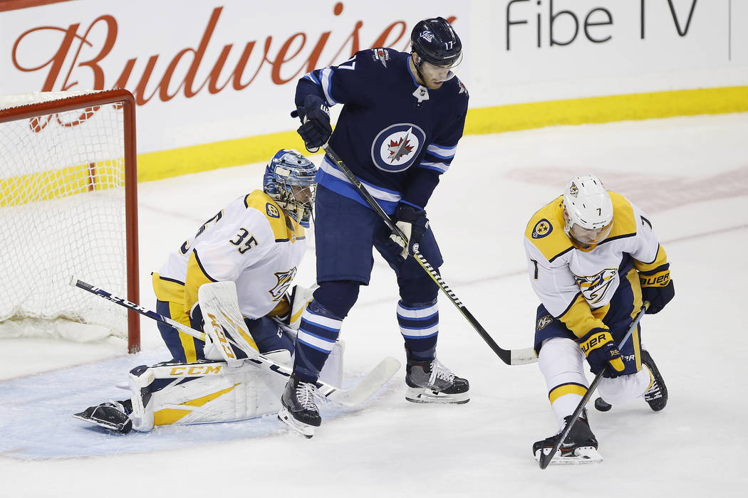 Nashville Predators' Yannick Weber (7) blocks the shot in front of Winnipeg Jets' Adam Lowry (17) and goaltender Pekka Rinne (35) during the first period of an NHL hockey game, Saturday, March 23, ...