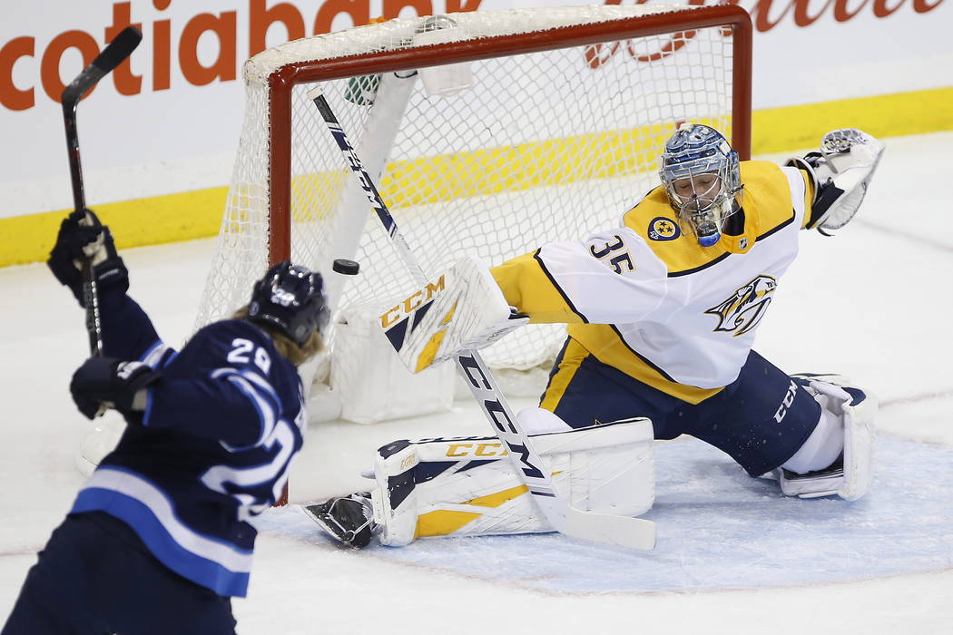 Winnipeg Jets' Patrik Laine (29) can't get the puck past Nashville Predators goaltender Pekka Rinne (35) as he makes the save during the first period of an NHL hockey game, Saturday, March 23, 201 ...