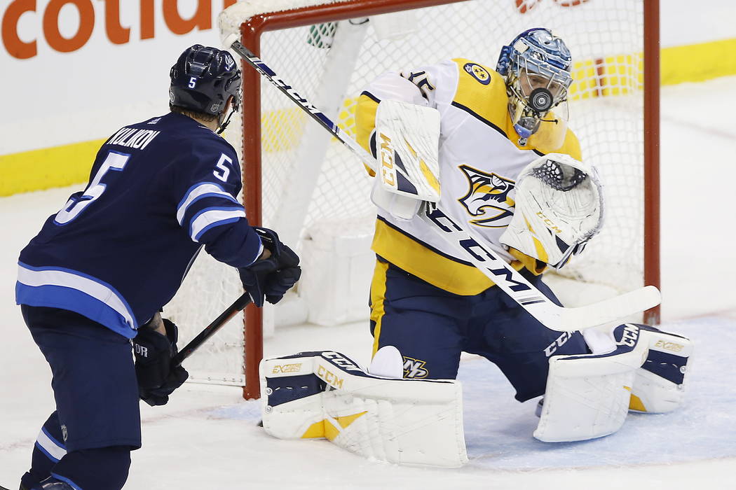 Winnipeg Jets' Dmitry Kulikov (5) looks for a rebound as Nashville Predators goaltender Pekka Rinne (35) makes the save during the first period of an NHL hockey game, Saturday, March 23, 2019 in W ...