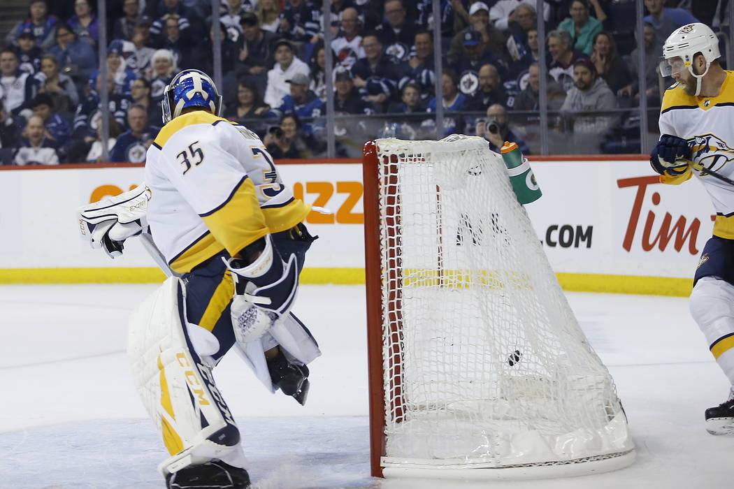 Winnipeg Jets' Andrew Copp (9) gets a shot in from behind the net after it rebounded off the pad of Nashville Predators goaltender Pekka Rinne (35) as Mattias Ekholm (14) looks on during the secon ...