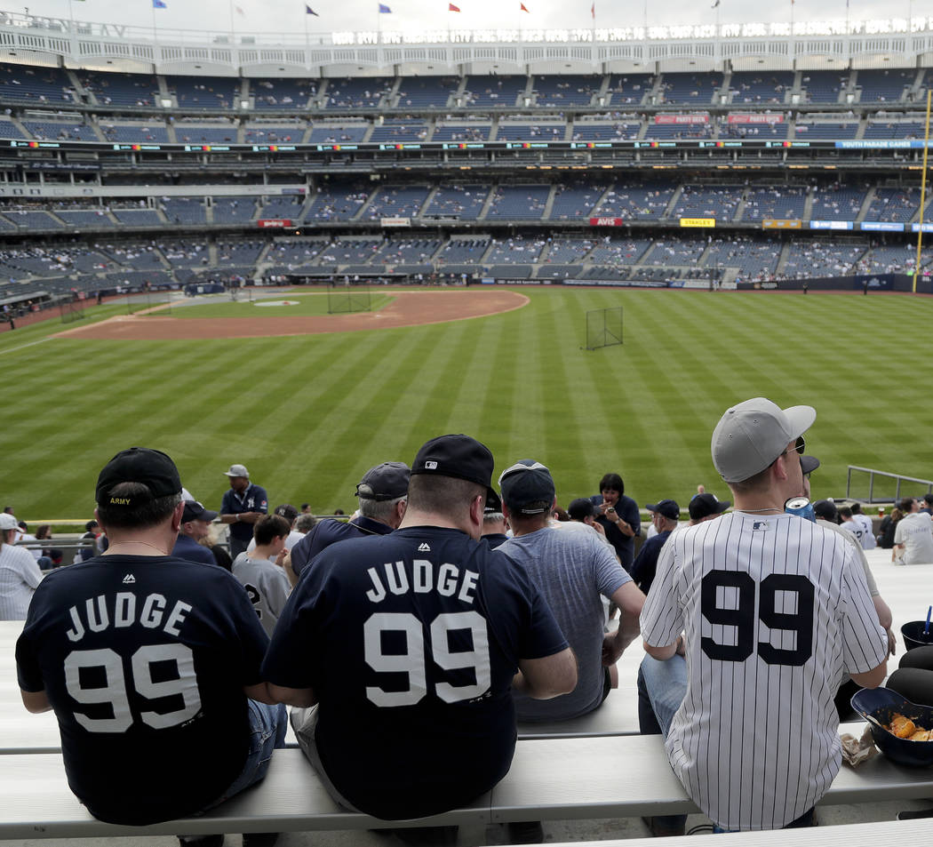 FILE - In this May 4, 2018, file photo, baseball fans wearing New York Yankees' Aaron Judge (99) jerseys watch batting practice before a baseball game between the New York Yankees and the Clevelan ...