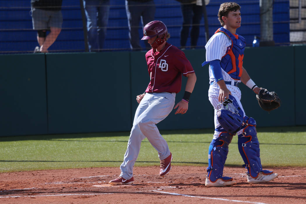 Desert Oasis Parker Schmidt (4) runs home for a run as Bishop Gorman's Gavin Mez (18) looks on in the baseball game at Bishop Gorman High School in Las Vegas, Thursday, March 21, 2019. Erik Verduz ...