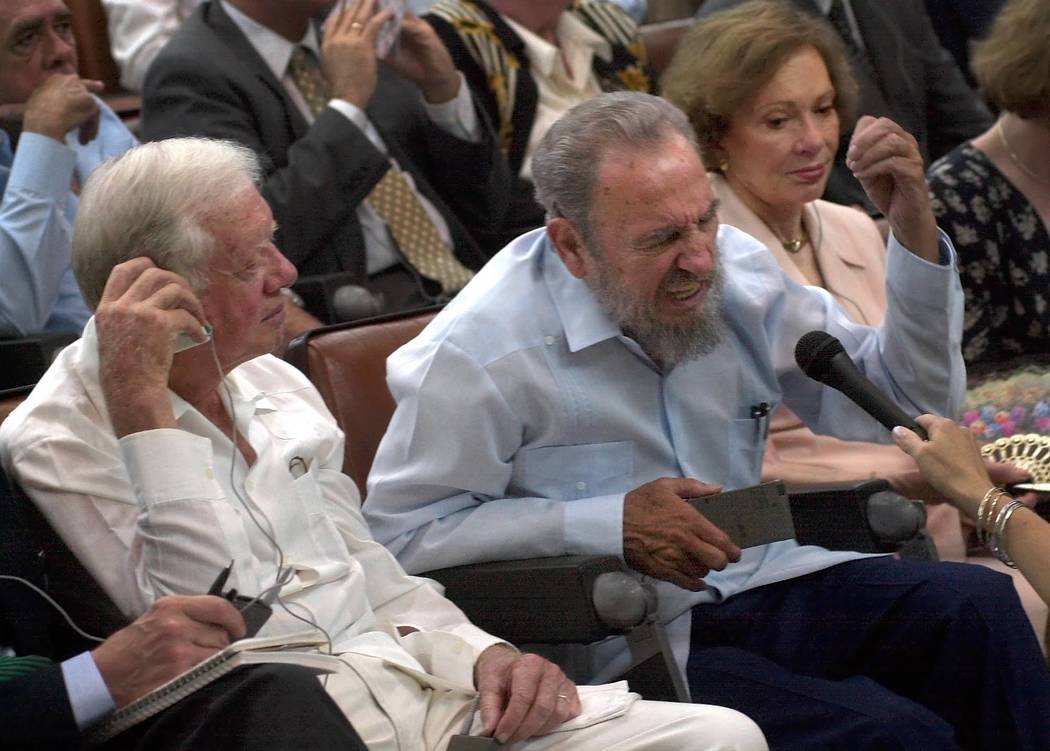 Former U.S. President Jimmy Carter, left, listens as Cuban President Fidel Castro speaks during a visit to a center for genetic engineering and biotechnology in Havana, Cuba, Monday, May 13, 2002. ...