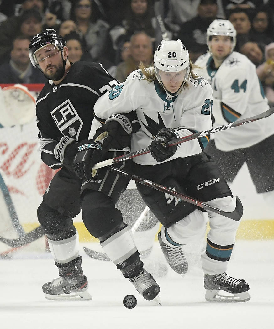 Los Angeles Kings defenseman Alec Martinez, left, and San Jose Sharks left wing Marcus Sorensen vie for the puck during the first period of an NHL hockey game Thursday, March 21, 2019, in Los Ange ...
