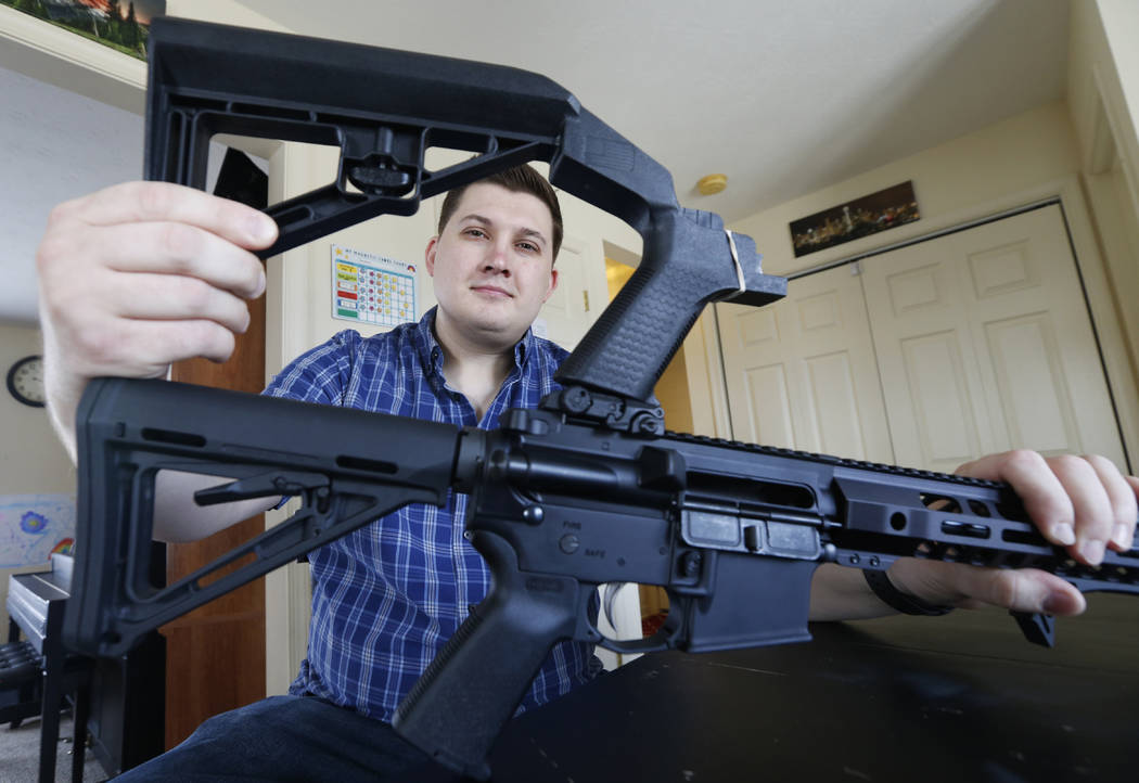 In this March 15, 2019 photo, Ryan Liskey displays a bump stock on top of his AR-15 at his home in Harrisonburg, Va. The ban on bump stocks is just a few days away and owners of the devices like L ...
