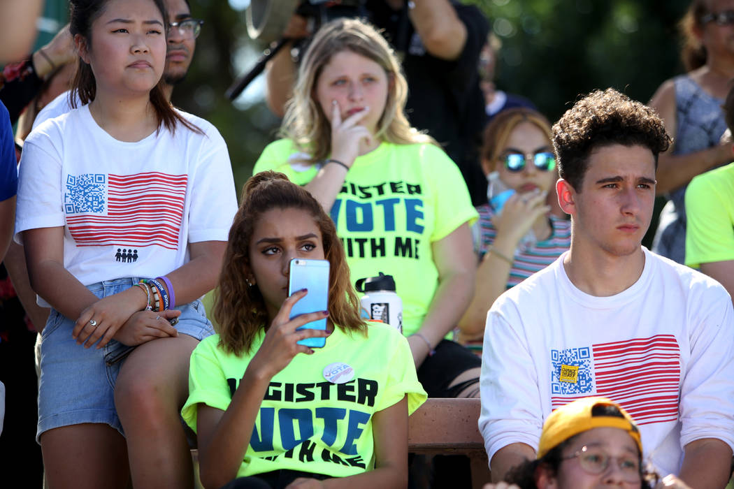 Kelly Choi, 17, from left, Franlisha Vasquez, 15, and Amit Dadon watch Manny Oliver create a mural at a Road to Change Voter Registration Walk at Sunset Park in Las Vegas, Monday, July 16, 2018. T ...