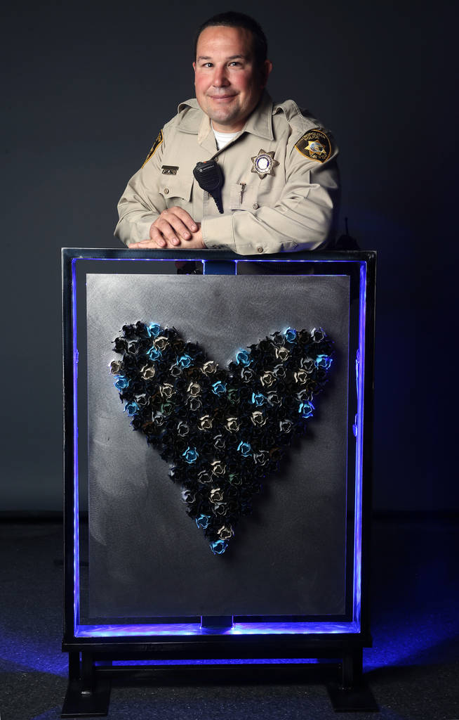 Metropolitan Police Department detective Darryl McDonald with his artwork at the Las Vegas Review-Journal photo studio Monday, March 25, 2019. McDonald created the piece for the "Cops & Canvas" fu ...