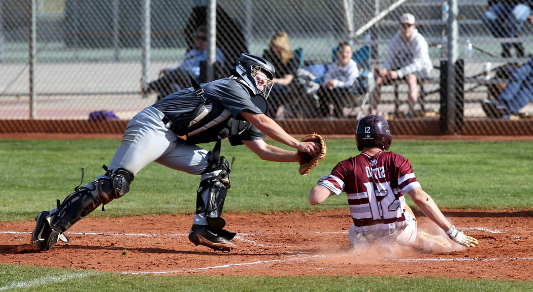 Cimarron-Memorial baserunner Anthony Ortiz (12) slides safely across home plate under the tag of Silverado catcher Brant Hunt (18) in the third inning of their baseball game at Cimarron-Memorial H ...