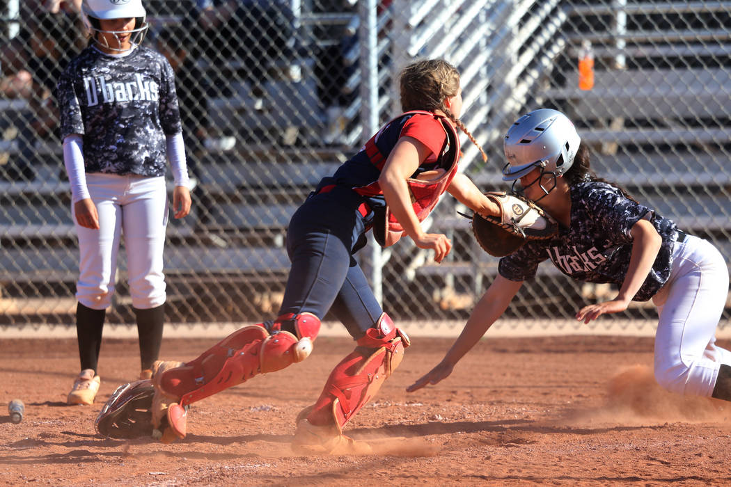 Liberty's McKenzie Hamilton (00) tags out Desert Oasis' Makayla Rickard (23) at home plate in t ...