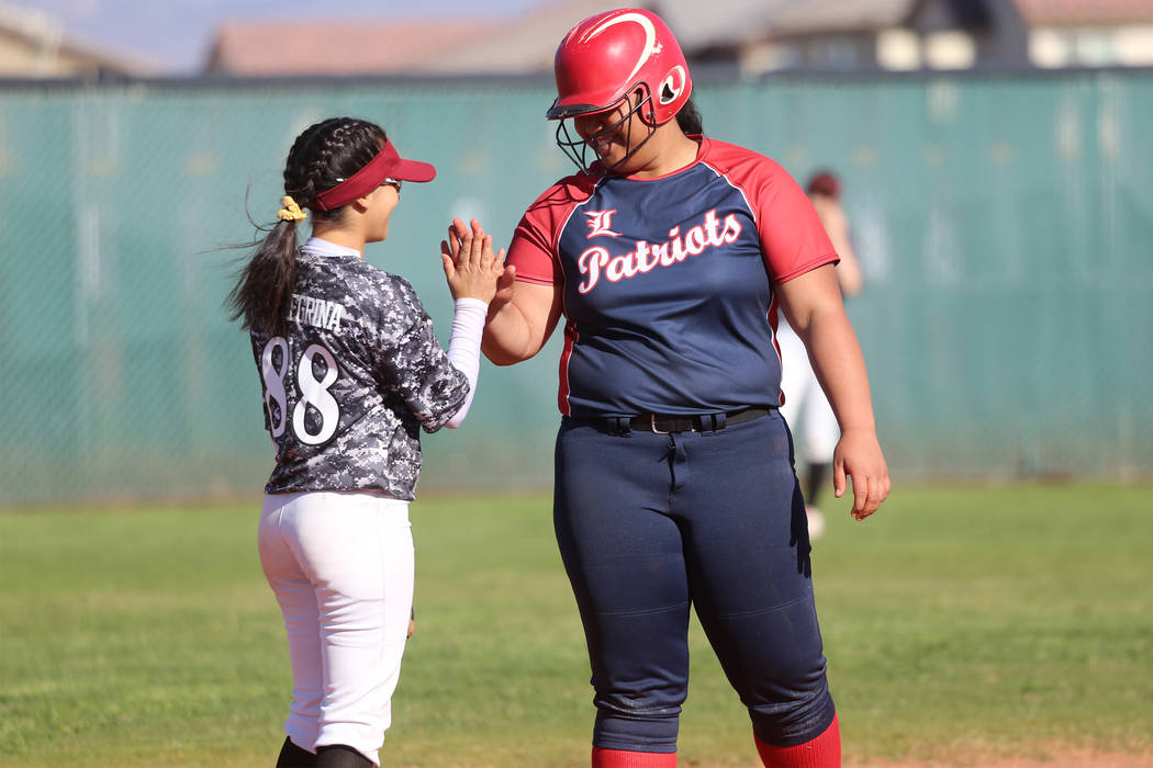 Desert Oasis' Yahirda Peregrina (88) high-fives Liberty's Fia Tofi (74) after Tofi's double in ...