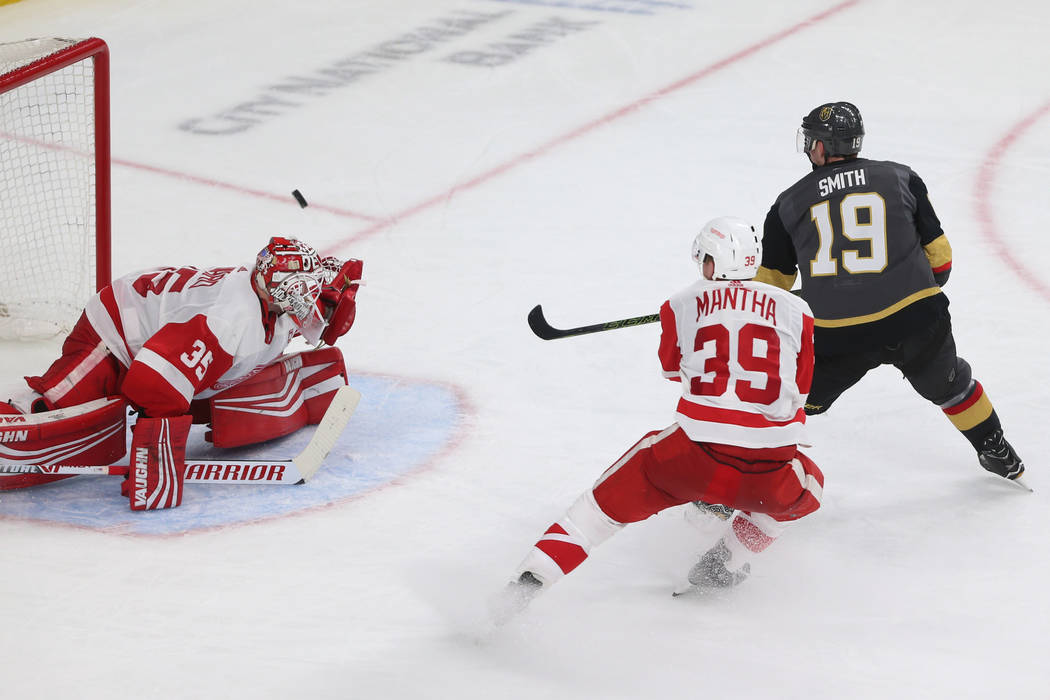 Vegas Golden Knights right wing Reilly Smith (19) shoots for a score against Detroit Red Wings goaltender Jimmy Howard (35) and right wing Anthony Mantha (39) during the third period of an NHL hoc ...