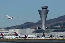 Air traffic control tower is in sight as a plane takes off from San Francisco International Airport in San Francisco on Oct. 24, 2107. (AP Photo/Jeff Chiu, File)