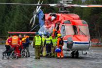 Passengers are helped from a rescue helicopter in Fraena, Norway, Sunday March 24, 2019, after being rescued from the Viking Sky cruise ship. Rescue workers are evacuating more passengers from a c ...