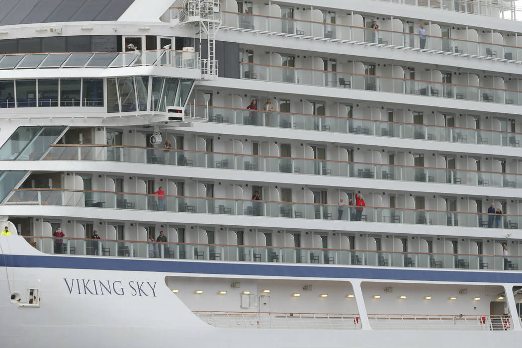 Some of the remaining passengers look out as the cruise ship Viking Sky arrives at port off Molde, Norway, Sunday March 24, 2019, after having problems and issuing a Mayday call on Saturday in hea ...