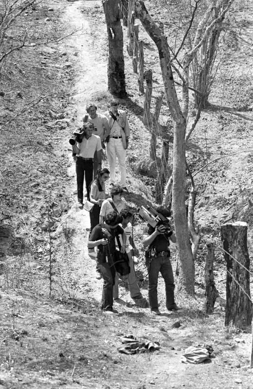 In this March 18, 1982 photo, television cameramen photograph blood-soaked, bullet-ridden clothes believed to belong to four Dutch journalists killed in a wooded area near this village in the prov ...
