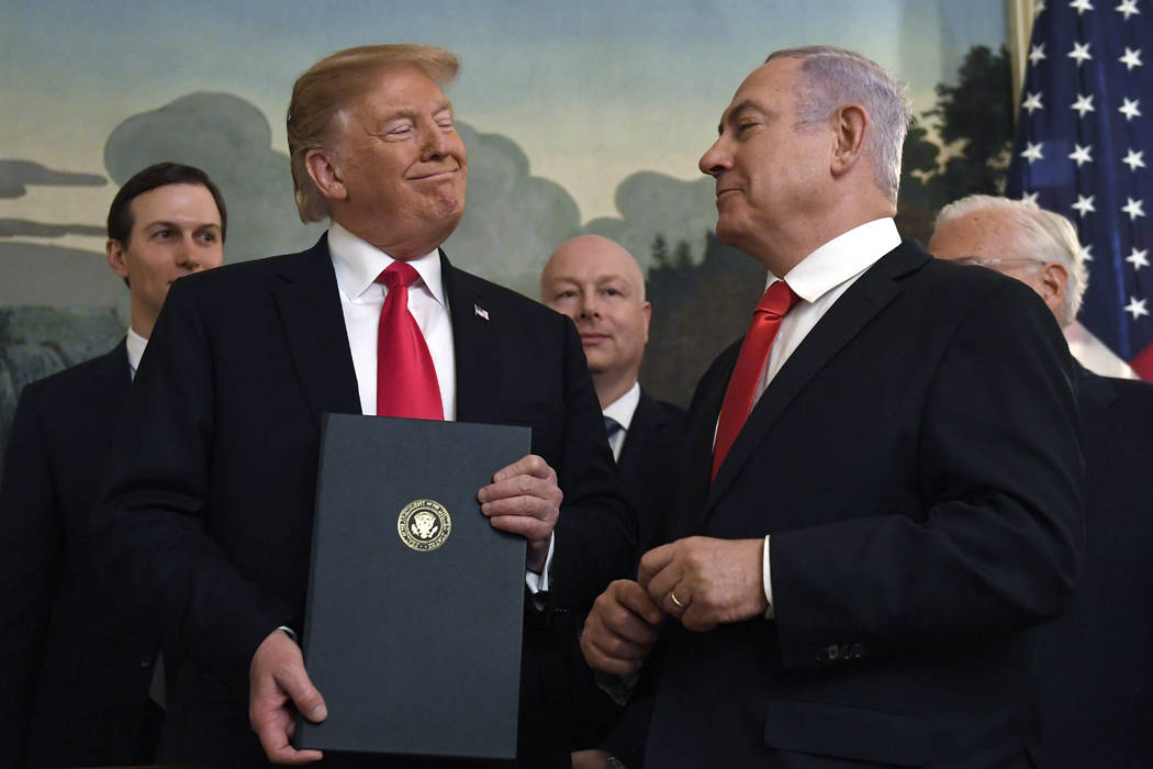 President Donald Trump smiles at Israeli Prime Minister Benjamin Netanyahu, right, after signing a proclamation in the Diplomatic Reception Room at the White House in Washington, Monday, March 25, ...
