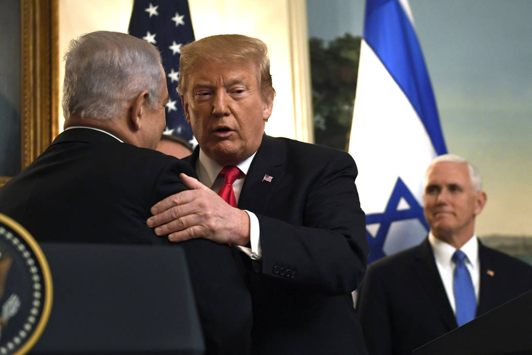President Donald Trump, center, embraces Israeli Prime Minister Benjamin Netanyahu, left, in the Diplomatic Reception Room of White House in Washington, Monday, March 25, 2019, as Vice President M ...