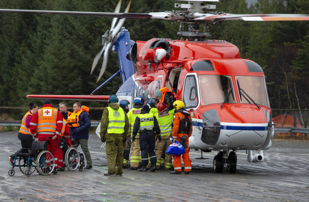 Passengers are helped from a rescue helicopter in Fraena, Norway, Sunday March 24, 2019, after being rescued from the Viking Sky cruise ship. Rescue workers are evacuating more passengers from a c ...