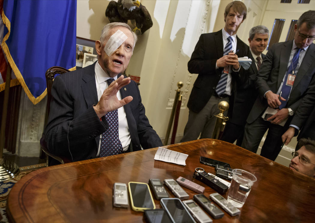 Then-Senate Minority Leader Harry Reid of Nevada talks to reporters on Capitol Hill in Washington, D.C., on Jan. 22, 2015, for the first time after suffering an eye injury and broken ribs while ex ...