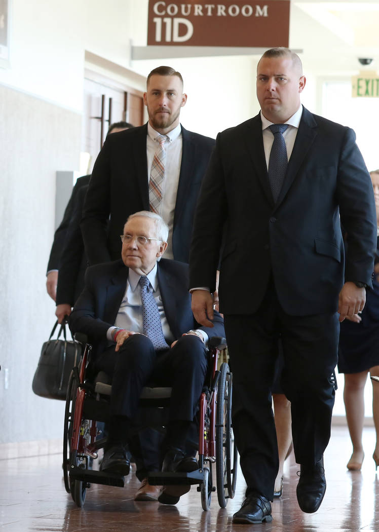 Former U.S. Sen. Harry Reid, who sued the makers of an exercise band after injuring his eye, leaves the courtroom in a wheelchair after attending the first day of jury selection in his civil trial ...
