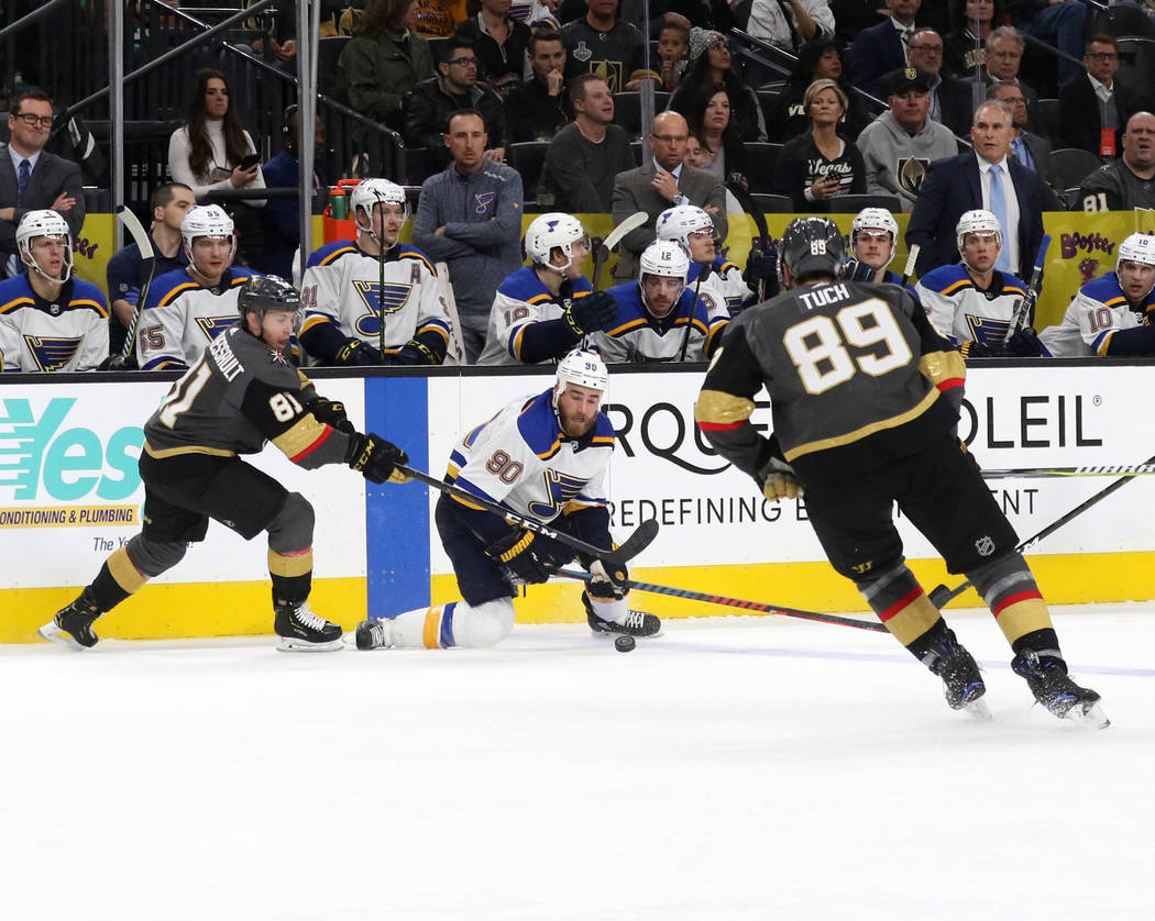 Vegas Golden Knights right wing Alex Tuch (89) skates towards center Jonathan Marchessault (81) and St. Louis Blues center Ryan O'Reilly (90) as they fight for the puck during the first period of ...