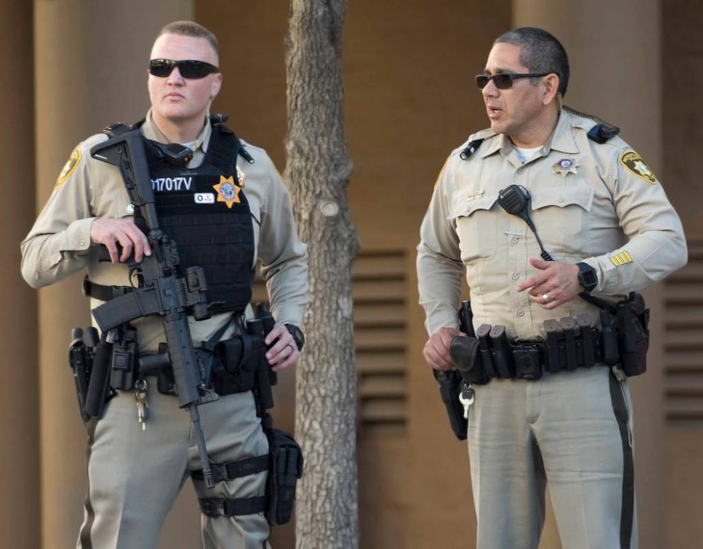 Metro officer Dallin Van Buskirk, left, armed with an AR-15 semi-automatic rifle with a scope, ...