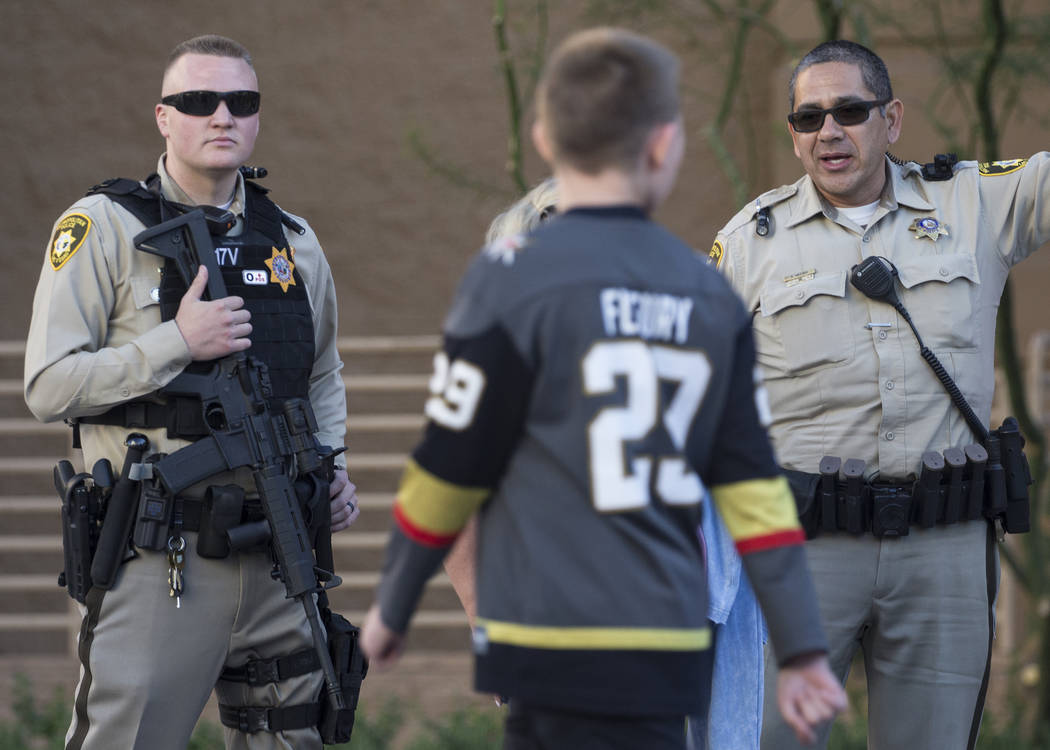 Metro officer Dallin Van Buskirk, left, armed with an AR-15 semi-automatic rifle with a scope, ...