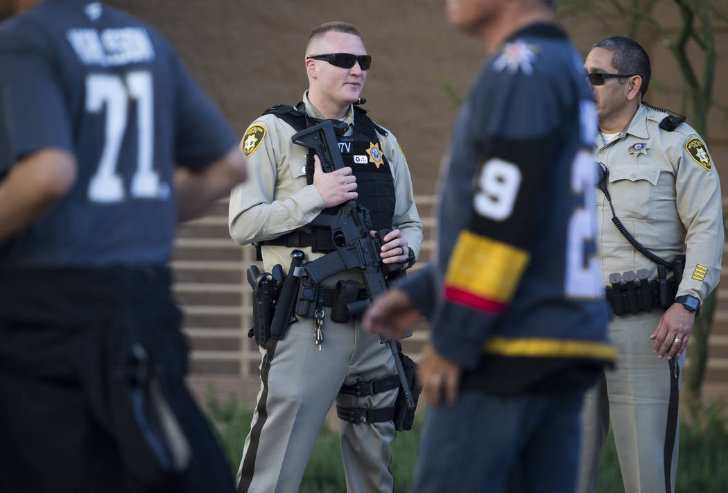 Metro officer Dallin Van Buskirk, left, armed with an AR-15 semi-automatic rifle with a scope, ...