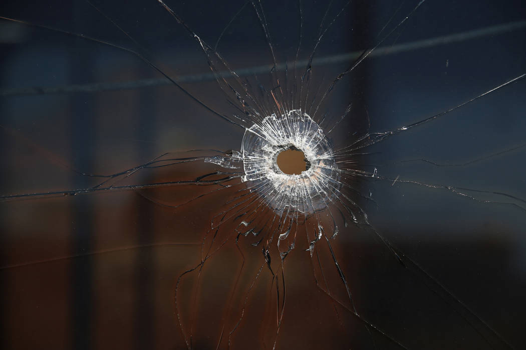 A bullet hole on the window of a bus donated to the Metropolitan Police Department firearms ran ...