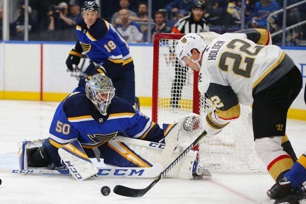 St. Louis Blues' goalie Jordan Binnington (50) looks to make a save against Vegas Golden Knights' Nick Holden (22) during the third period of an NHL hockey game Monday, March 25, 2019, in St. Loui ...