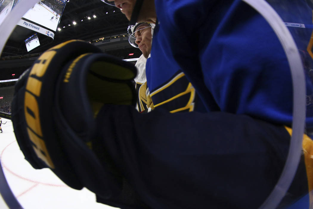 Vegas Golden Knights' Valentin Zykov (7), of Russia, checks a member of the St. Louis Blues into the boards during the first period of an NHL hockey game Monday, March 25, 2019, in St. Louis. (AP ...