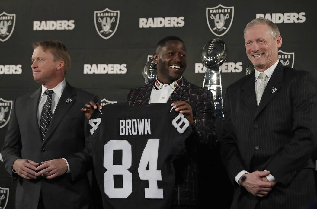 Oakland Raiders wide receiver Antonio Brown, center, holds his jersey beside coach Jon Gruden, left, and general manager Mike Mayock during an NFL football news conference Wednesday, March 13, 201 ...