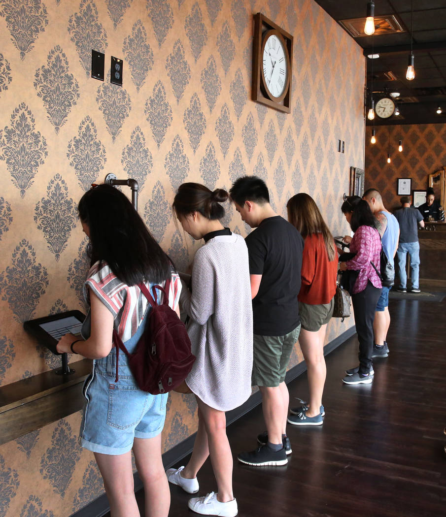 Customers sign a waiver at Escapology, where players are locked inside a themed room to play a high adrenaline escape game, before their game on Tuesday, March. 26, 2019, in las Vegas. Bizuayehu T ...