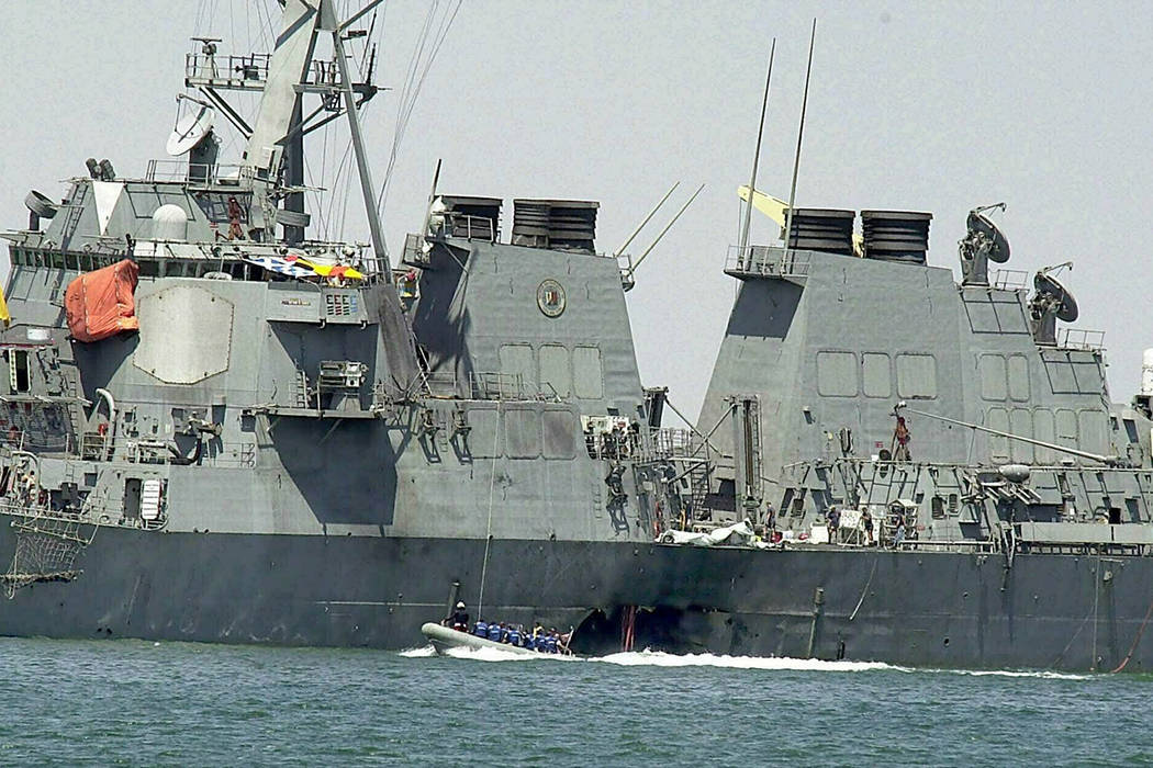Experts in a speed boat examine the damaged hull of the USS Cole at the Yemeni port of Aden after an al-Qaida attack that killed 17 sailors on Oct. 15, 2000. The Supreme Court on Tuesday threw out ...