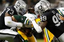 Green Bay Packers quarterback Brett Hundley, center, is sacked by Oakland Raiders defensive tackle Maurice Hurst (73) and defensive end Fadol Brown, obscured, during the first half of an NFL prese ...