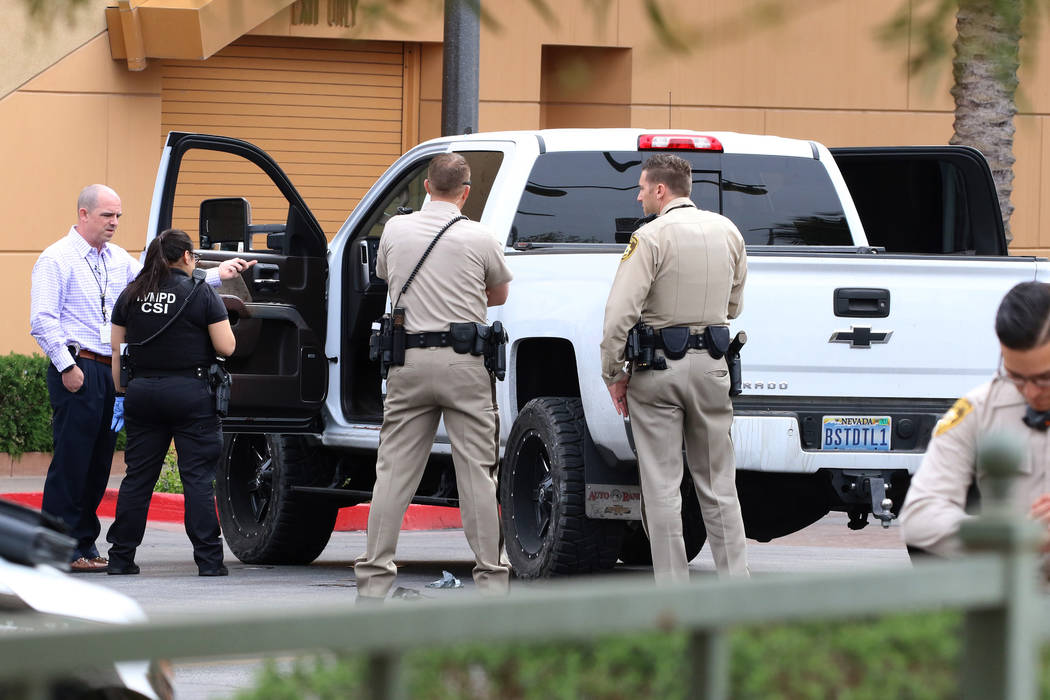 Las Vegas police surround a white pickup truck as they investigate after a pursuit related to a ...