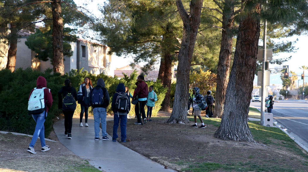 Students wait for the school bus on Soaring Gulls Drive near Cheyenne Avenue at Desert Shores V ...