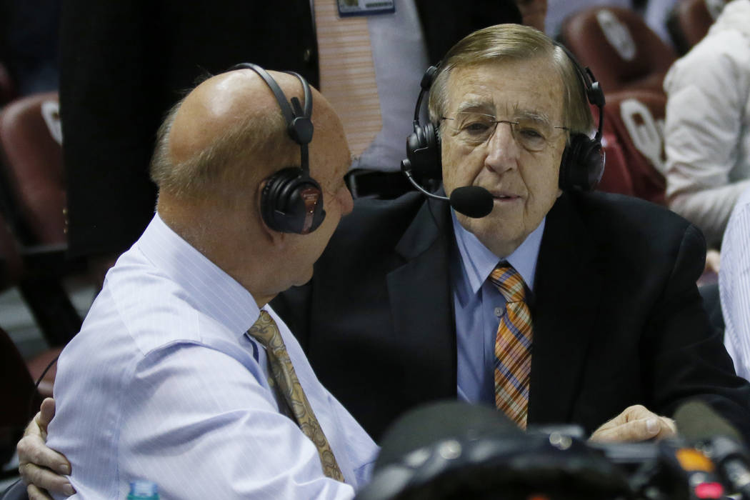 Brent Musburger, right, talks with Dick Vitale, left, following an NCAA college basketball game ...