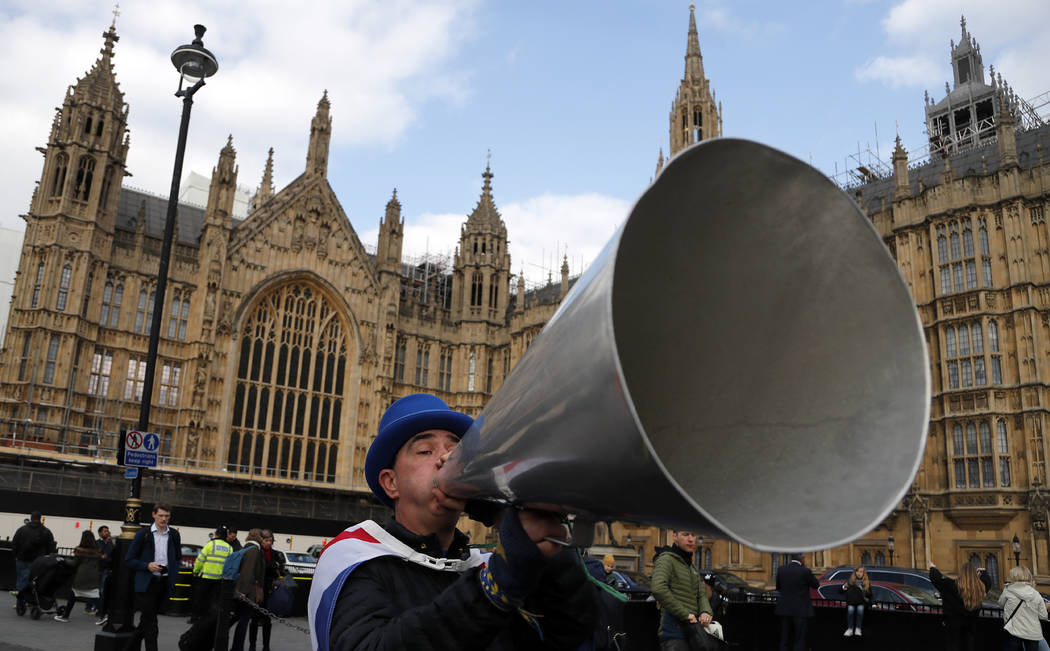 A pro EU protestor shouts through a megaphone at the Houses of Parliament in London, Wednesday, March 27, 2019. British lawmakers were preparing to vote Wednesday on alternatives for leaving the E ...