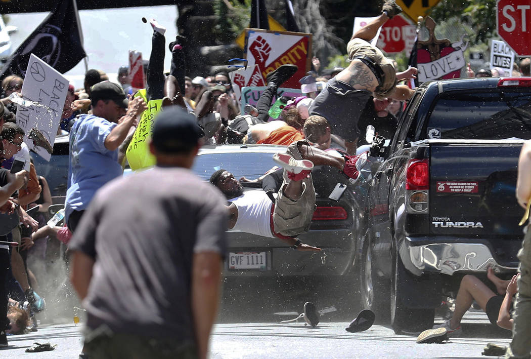 FILE - In this Aug. 12, 2017 file photo, people fly into the air as a vehicle is driven into a group of protesters demonstrating against a white nationalist rally in Charlottesville, Va. A man con ...