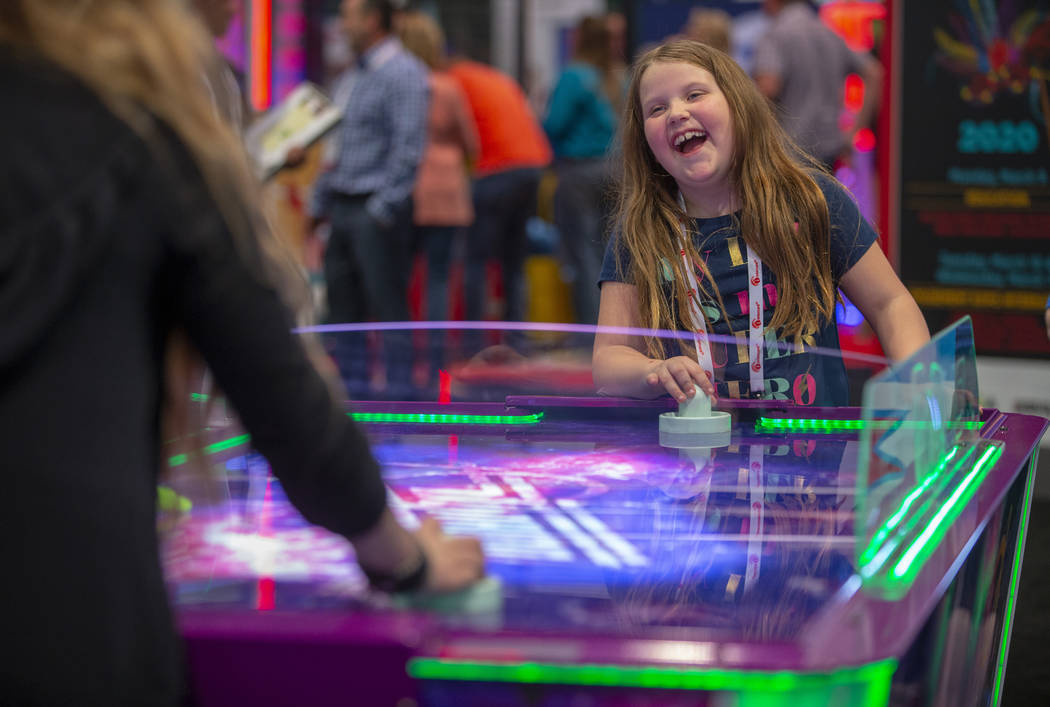 Evva Fortier with Gamepath Arcade plays air hockey with a friend during the the Amusement Expo ...