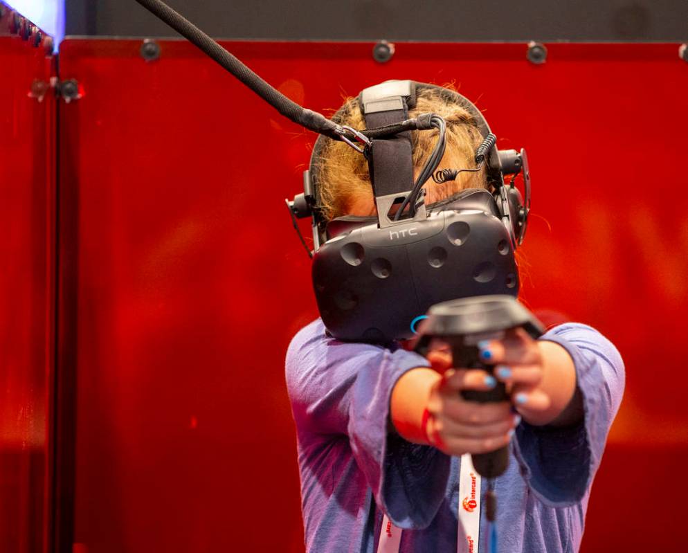 Adelle Evans of Reno, Nevada, tries out a VR Maze game by Triotech during the Amusement Expo at ...