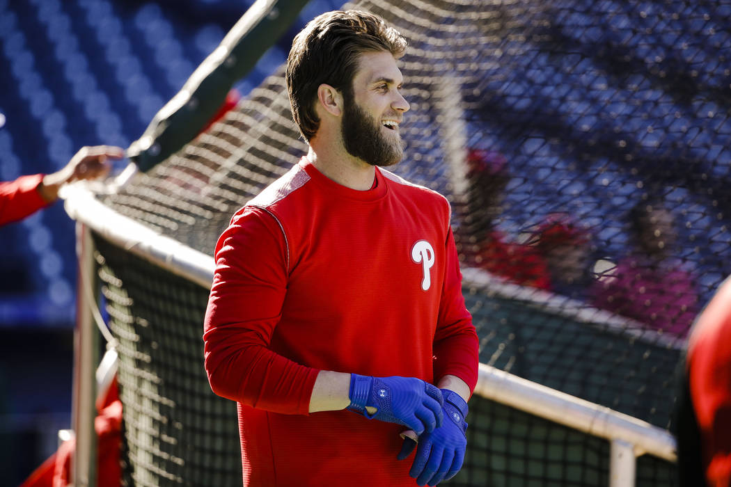 Philadelphia Phillies' Bryce Harper pulls on his gloves for batting practice, Tuesday, March 26 ...