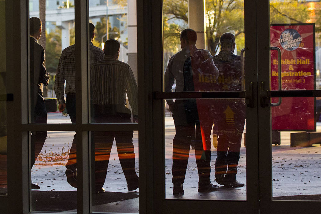 Plainclothes police officers walk out of the Las Vegas Convention and Visitors Authority office ...