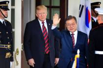 South Korean President Moon Jae-in waves as he is welcomed by President Donald Trump to the Whi ...