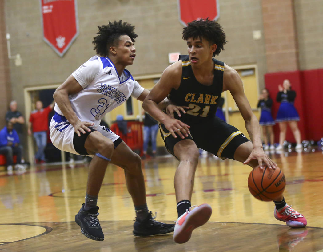 Clark's Jalen Hill (21) moves the ball around Desert Pines' Jamir Stephens (33) during the seco ...