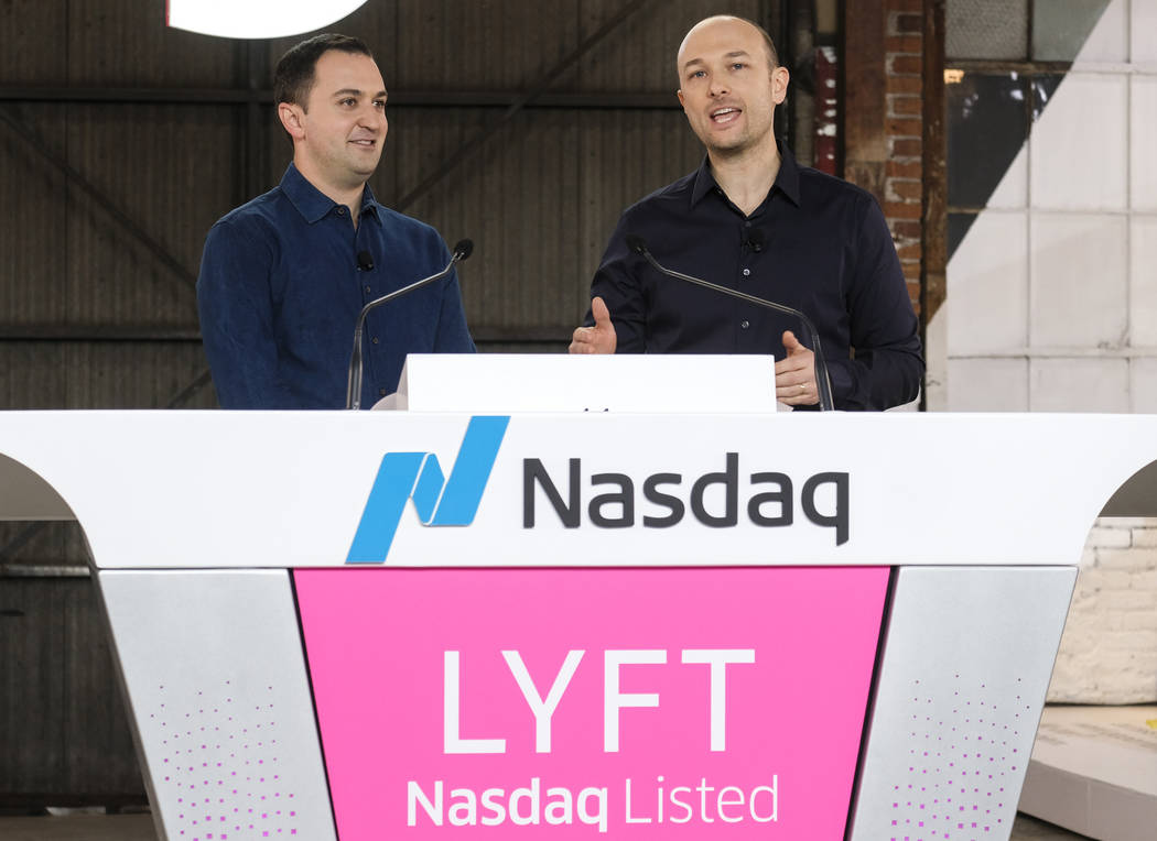 Lyft co-founder John Zimmer, left, listens as fellow co-founder Logan Green speaks before they ...